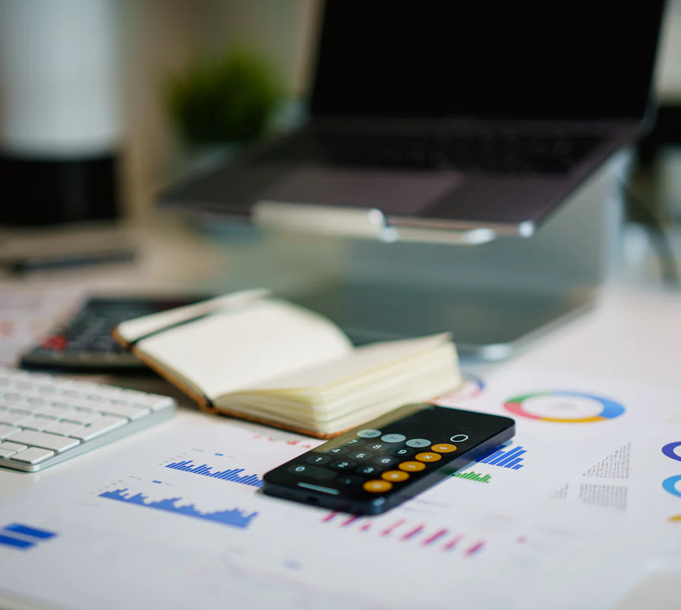 Mesa com calculadora e relatórios financeiros